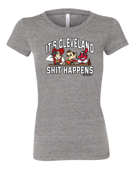 A grey women's t-shirt with the text 'IT'S CLEVELAND SHIT HAPPENS' on the front, featuring cartoonish sports characters.